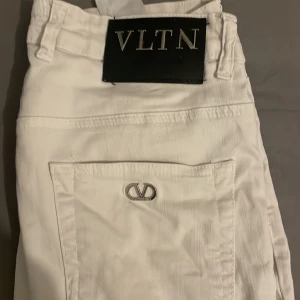 Vita jeans från Valentino - Snygga vita jeans från Valentino med VLTN-logga. Byxorna har en klassisk design med fickor bak och en knapp med logotyp. Perfekta för en stilren look. Köpta från bestsecret nypris 2699 mitt pris 500. Pris kan diskuteras 