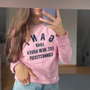 Rosa sweatshirt från GANT - Säljer en rosa sweatshirt från GANT med tryck i marinblått på framsidan. Tröjan har långa ärmar och en rund halsringning. Knappt använd
