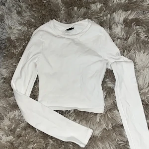Vit topp Gina Tricot 😍 - Säljer en stilren vit topp med långa ärmar från Gina Tricot den är som ny 💞💕😍använd bara för att ta bilder! Tröjan har långa ärmar som jag personligen gillar 🥰materialet är stretchigt 