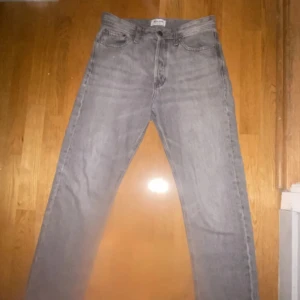 Grå jeans från Jack & Jones - Snygga grå jeans från Jack & Jones med klassisk femficksdesign. De har en rak passform och är tillverkade i slitstarkt denim. Perfekta för en avslappnad stil. 9/10 kvalitet knappt använd