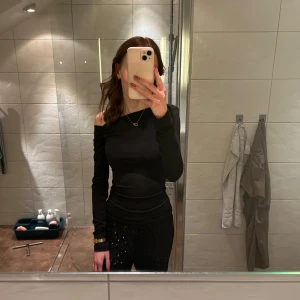 Svart offshoulder topp - Snygg svart offshoulder topp med långa ärmar. Perfekt för en kväll ute eller en stilren vardagslook. Toppen har en tight passform som framhäver figuren. Storlek Xs. 🫶🏽🫶🏽helt ny, använd 1 gång på nyår iår!!