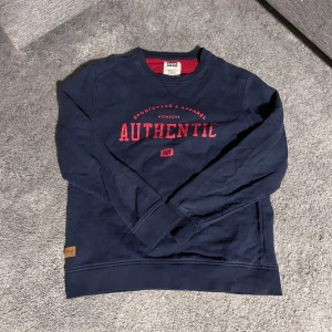 Mörkblå sweatshirt från WA - Säljer en mörkblå sweatshirt från WA med röd text 'AUTHENTIC' på framsidan. I bra skick då den är gammal men knappt använd. Skriv vid frågor 