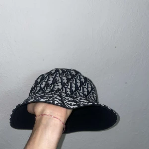 Mönstrad hatt från CD - Snygg och trendig hatt från CD med ett svart och vitt mönster. Perfekt för att ge din outfit en lyxig touch. Hatten har en klassisk form och är tillverkad i ett bekvämt material.