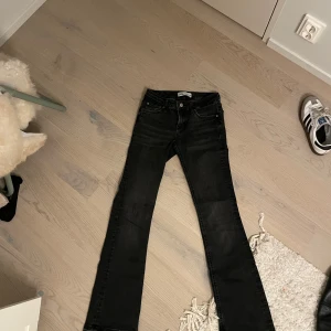 Svarta/gråa jeans - As snygga svarta Low Waist flare jeans med slitningar längst ner!! De är ifrån Zara i storlek 34