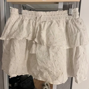 Vit kjol från Gina Tricot - Jättefin kjol från ginatricot med guld detaljer. Kjolen är från gina Young i storlek 170 men passar xs/s.
