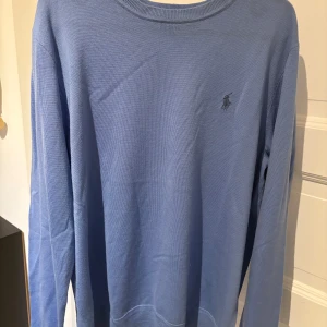 Blå tröja från Polo Ralph Lauren - Säljer en stilren blå tröja från Polo Ralph Lauren med broderad logga på bröstet. Tröjan har långa ärmar och en rund halsringning, perfekt för en avslappnad look. Nypris cirka 1700kr. Säljer nu för den var för stor eftersom jag själv har S. Köpte ny och inte använt mer än 1 gång. Säljer för 699 nu men pris kan diskuteras något litet!!