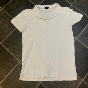 Vit pikétröja från Hugo Boss - Snygg vit pikétröja från Hugo Boss i mjuk pima bomull. Tröjan har en klassisk krage och korta ärmar, perfekt för en stilren look. Diskret broderad logga på bröstet. Storleken är S men passa nog även XS. Nypris 1000kr mitt pris 250kr.