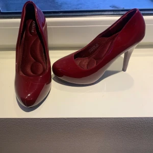 Röda pumps med klack - Snygga röda pumps med hög klack och rundad tå. Perfekta för en elegant look.