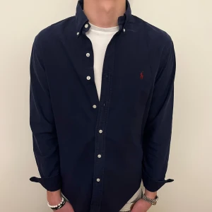 Mörkblå Ralph Lauren skjorta -  Nu säljer vi ännu en fet polo skjorta som passar till alla tillställningar, skjortan är i mycket bra skick och passar allt från fest till vardagsbruk!🕺🍾💼🤩  Storlek👔: M Nypris💰:  ca 1499kr