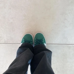 Gröna sneakers från Adidas - Snygga gröna sneakers från Adidas med vita ränder och en klassisk design. Perfekta alla stilar.