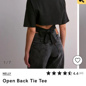 Svart öppen rygg knyt topp från Nelly - Snygg svart topp från Nelly med öppen rygg och knytning. Perfekt för en trendig look. Kortärmad design som ger en stilren och modern känsla. slutsåld på hemsidan