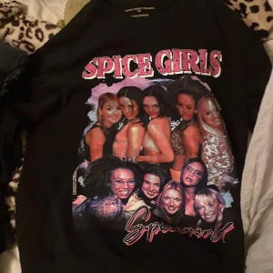 Svart Spice Girls tröja - Säljer en svart tröja med ett stort tryck av Spice Girls på framsidan. .är från iconsliving.com orginalpris ca 300kr.