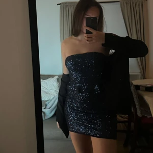 Svart glittrig axelbandslös klänning - Snygg svart axelbandslös klänning med glittrande detaljer. Perfekt för en kväll ute eller fest. Nypris på zara 699kr