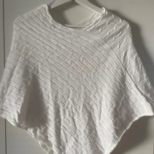 Vit Poncho  - Vit kofta/tröja. Stickad med jätte fint mönster. Passar Xs-M