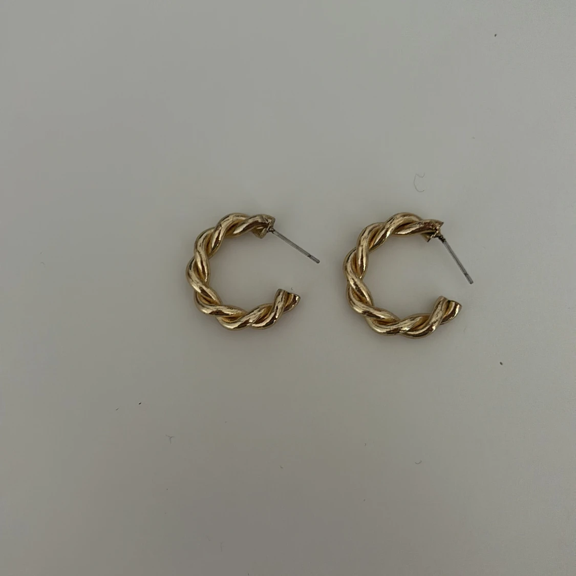 Guldiga tvinnade örhängen