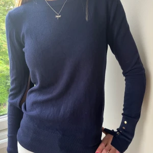 Mörkblå tröja från Zara - Säljer en mörkblå tröja från Zara i storlek S. Tröjan är långärmad och har en normal passform. Den är tillverkad i ett mjukt och bekvämt material, perfekt för höst och vinter. Tröjan har även en fin detalj med knappar vid ärmsluten. den har ett hål i högra ärmen som är ungefär en decimeter, som är enkelt att sy igen. skriv för fler bilder eller frågor!