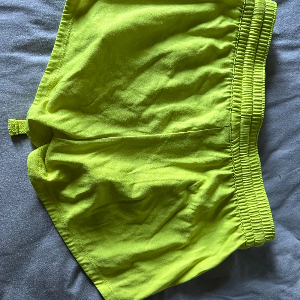 Säljer två par shorts den ena från Champion i storlek medium. Ett par är knallgula och det andra paret är mörkgröna. Båda har en elastisk midja med dragsko för justering. Perfekta för träning eller en avslappnad dag. De är i bra skick och redo för nya äventyr!. Shorts.