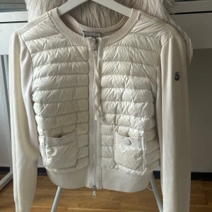 Moncler cardigan  - Vit Moncler Cardigan i användt skick men ser fortfarande väldigt fin ut. Ett litet hål i armhålan som går att fixa, skriv privat för fler bilder inklusive på hålet. Köparen står för frakt  