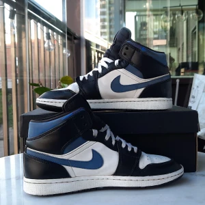 Jordan 1 Mid White & Racer Blue 41 - Säljer mina Jordan 1 Mid i fint skick. Normal användning och lite märken här och där, men absolut inga stora märken. Lite creasade men är fortvarande väldigt fräscha.  Skriv vid funderingar! :)  OBS Kommer endast med svarta skosnören! Nypris ca 2700