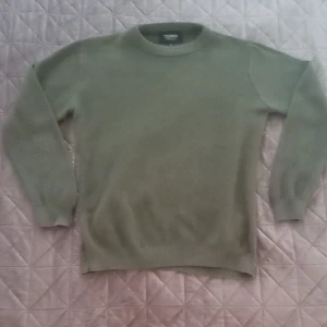 Olivgrön stickad tröja från Pull&Bear - Säljer en snygg olivgrön stickad tröja från Pull&Bear. Perfekt för höst och vinter med sin mysiga och varma känsla. Tröjan har en klassisk rund hals och långa ärmar, vilket gör den superbekväm. Den är i storlek S och passar perfekt för en casual look. Tillverkad i Turkiet, så du vet att kvaliteten är på topp!