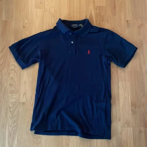 Ralph Lauren Polo Piké - Säljer denna marinblåa polo pikén i bra skick!💙 Använd ett par gånger men annars som ny,Priset är ej hugget i sten!