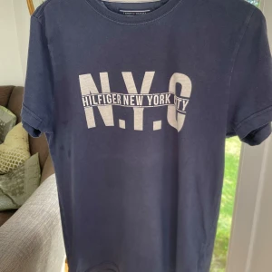 Marinblå Tommy Hilfiger T-shirt  - Säljer nu denna sjukt snygga Tommy Hilfiger T-shirt. Tröjan är i storlek S och är i bra skick utan några defekter. Säljer den nu för 80!  Hör av dig om du har fler frågor!