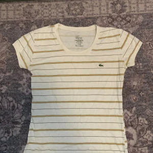 Randig tshirt  - En fin grön och orange randig tshirt från lacoste. Skulle säga storlek s/m 🧡💚