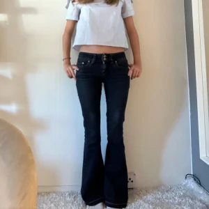 Lågmidjade mörkblå jeans - Lågmidjade utsvängda mörkblå jeans!! Midjemått: 68 Innerbenslängd: 78