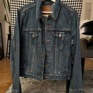 LEVIS Jeansjacka  - Säljer min fina Levis jeansjacka i kanon skick. Använd vid enstaka tillfällen. Färg: Mörkare blå tvätt. Storlek: M passar även S.