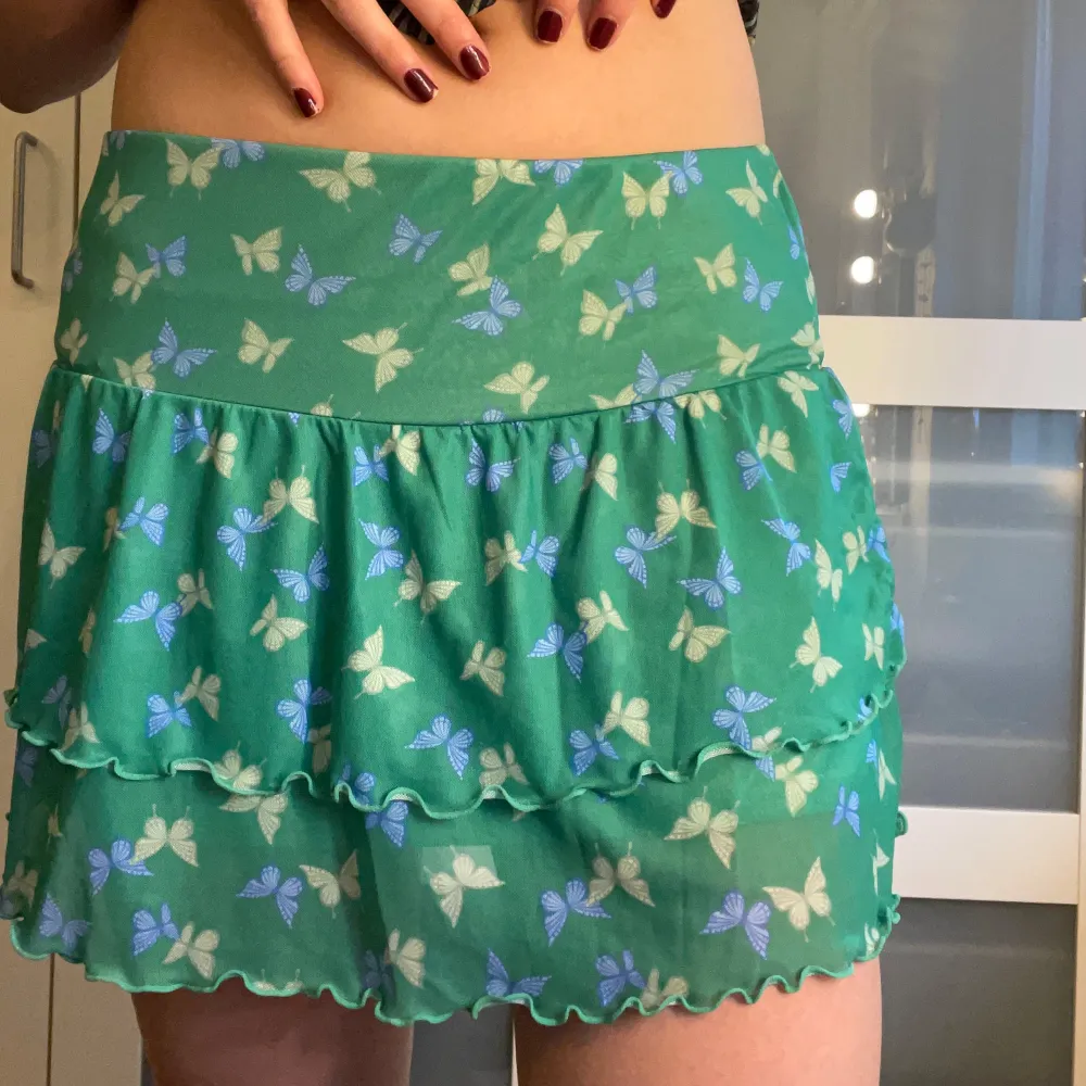 Söt miniskirt i grön färg med fjärilar! Dubbelt tyg. I mycket fint skick!!   Säljer en matchande topp längre ner på min sida;) . Kjolar.