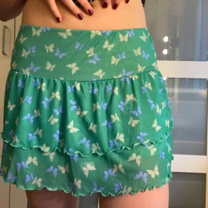 Miniskirt - Söt miniskirt i grön färg med fjärilar! Dubbelt tyg. I mycket fint skick!!   Säljer en matchande topp längre ner på min sida;) 