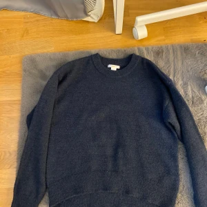 Mörkblå stickad tröja  - Säljer en supermysig mörkblå stickad tröja från gina. Perfekt för kalla dagar med sin varma och mjuka känsla. Tröjan har långa ärmar och en klassisk rund halsringning. Passar perfekt till både vardag och mysiga hemmakvällar. Nyskick aldrig använd 💓