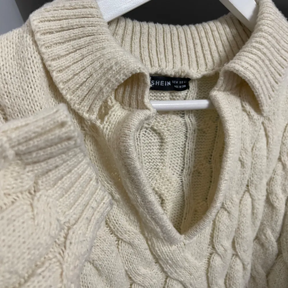 Säljer en superfin beige stickad tröja från Shein. Den har en snygg kabelstickad design och en v-ringad krage som ger en stilren look. Tröjan är croppad, har långa ärmar, perfekt för höst och vinter. Den är i bra skick och passar perfekt till både . Tröjor & Koftor.