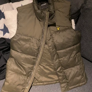 Väst- Lyle & SCOTT  - Säljer denna snygga olivgröna väst, i jätte bra skick användes fåtal gånger och inga märken eller något sådant alls. Skriv vid fundering.