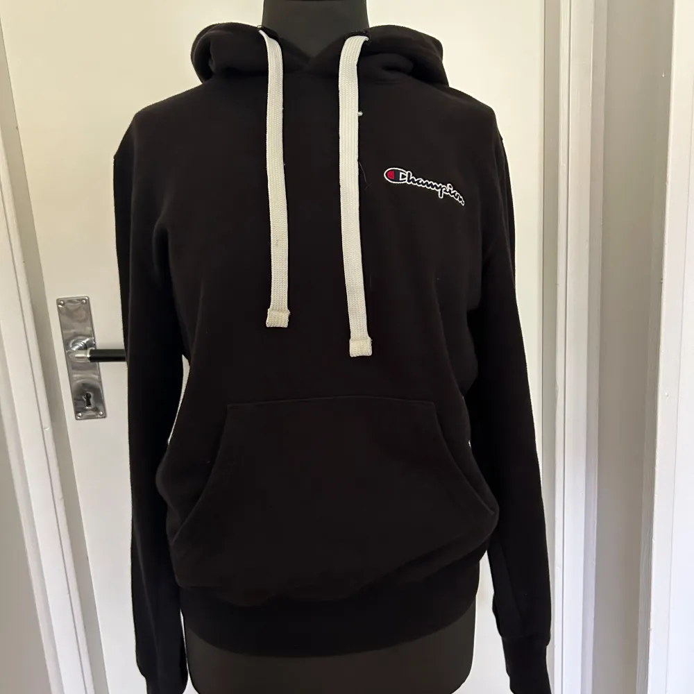 Säljer en svart hoodie från Champion i nyskick. Hoddien är perfekt för höst och vinter, och den är supermjuk och bekväm. Passar både till vardags och chillkvällar. . Neuletakit & Villapaidat.