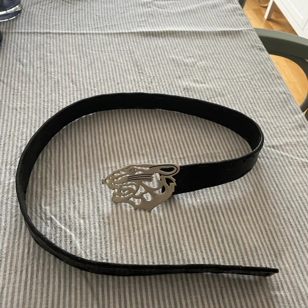 Svart läderbälte från Tiger med tigerbuckle (95cm). Accessoarer.