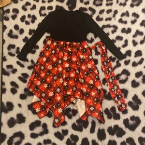 Jul klänning  - En fin julig klänning, bra och rent skick, inte trasig, v- ringad. Matchande bälte och använd en eller två Jular. Pris går att diskutera. 