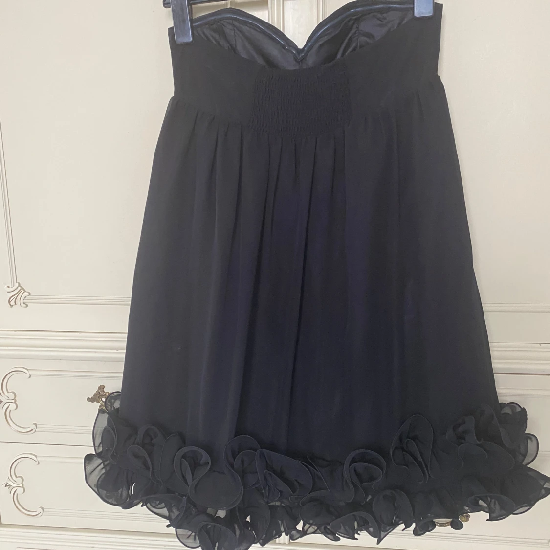Svart axelbandslös klänning med volang  - 90