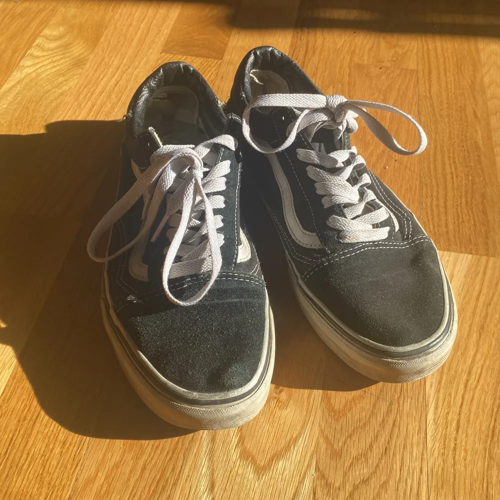 Säljer ett par svarta Vans sneakers i välanvänt skick. De har den klassiska vita sidostripen och vita snören. Skorna har en vit sula som är lite smutsig, men de är fortfarande superbekväma och perfekta för vardagsbruk.. Skor.