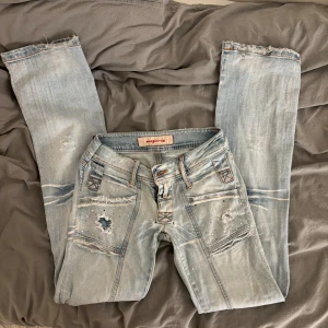 Slitna lågmidjade bootcut jeans - Intressekoll på mina skitcoola jeans! Säljer endast vid bra pris så kom med prisförslag!(Finns några defekter, kom privat så skickar jag bild!)