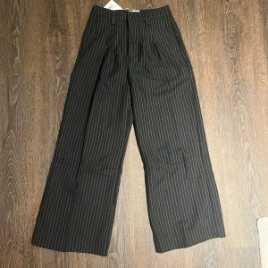 Jaded london Kostymbyxor - Jaded london kostymbyxor med en baggy passform. Plagget har alldrig blivigt andvänt och har till och med orginal lappen kvar. Säjler byxorna eftersom att jag fick byxorna som en julkapp men dem passar inte mig stolek är W26 Nypris är 1300kr. Om mer frågor så skriv