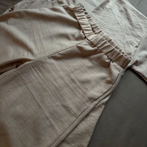 Beige linnebyxor i sett - Snygga beige linnebyxor med elastisk midja för extra komfort. Perfekta för en avslappnad stil med en luftig känsla. Passar bra till både vardag och sommarens äventyr.