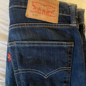 Levis 508 jeans - Snygga Levis 508 jeans i en klassisk blå färg. De har en straight passform och är tillverkade i slitstarkt denim. Perfekta för en avslappnad stil med fem fickor och knappgylf. Slim/straight sitter de. 