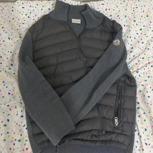 Moncler Cardigan - Snygg brun dunväst från Moncler med dragkedja och broderad logga på bröstet. Perfekt för lager-på-lager under kyliga dagar. Inga defekter, sitter som S-M. perfekt nu inför våren. Kvitto finns (visas upp efter köp) Jackan är i storlek S alltså 1