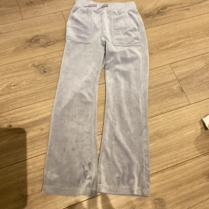 Grå mjukisbyxor med fickor - Säljer ett par grå mjukisbyxor med breda ben och praktiska fickor framtill. Byxorna har en bekväm resår i midjan och är perfekta för en avslappnad stil. De är tillverkade i ett mjukt material som känns skönt mot huden.