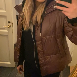 Brun dunjacka - Säljer en snygg brun dunjacka. Jackan har dragkedja fram. Perfekt för höst och vinter! Från Nelly i storlek 40. 100% polyester