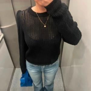 Svart stickad tröja - Snygg svart stickad tröja med långärmad design. Perfekt för lager-på-lager-stil med sitt genombrutna mönster. En stilren och mångsidig tröja för alla tillfällen. Lappen är tyvärr borta så vet inte storlek! Skulle gissa på S/M<33