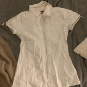 Söt vit blus med rosetter 💘 - Fin sommarblus som sitter tajt ❤️tröjan har två små fläckar på baksidan 