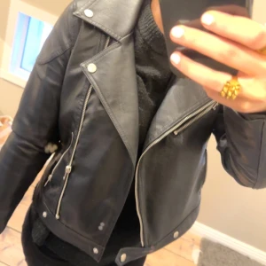 Svart skinnjacka från Noisy May - Snygg svart skinnjacka från Noisy May med fina dragkedjedetaljer och knappar. 
