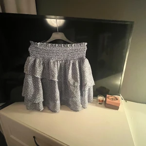 Leopardmönstrad kjol med volanger - Trendig leopardmönstrad kjol med volanger och elastisk midja. Perfekt för att ge en cool touch till din outfit. Kjolen har en luftig passform och är lätt att matcha med olika toppar.